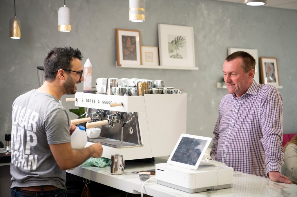 A barista making coffee for a customer at the Sugar Snap Kitchen café