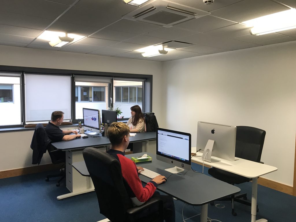 Another view of the Unbranded Digital office at Hope Park, with desks along the windows